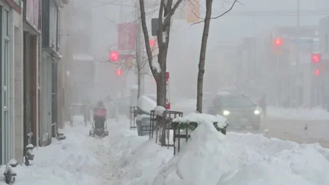 Man pushing stroller in winter storm Stock Footage 168781084