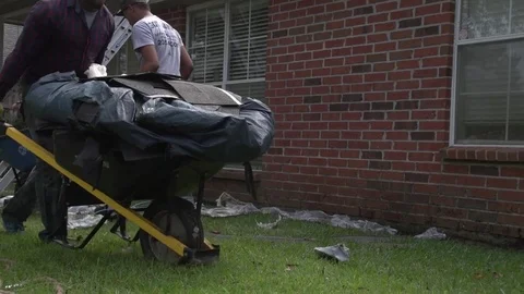 Man Pushing Wheel Barrow full of Debris Through Yard Slow Motion 動画素材 85365042