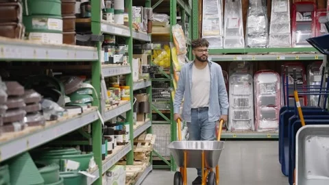 Man pushing wheelbarrow in hardware store aisle Stock-Footage 336965612
