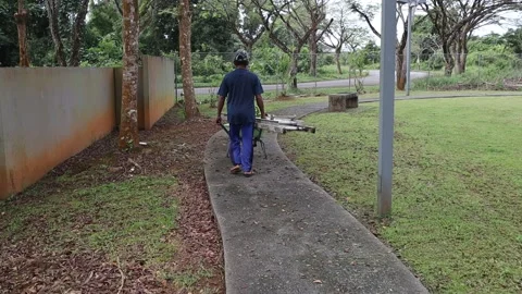 Man pushing wheelbarrow by the side of the house Stock Footage 170168465