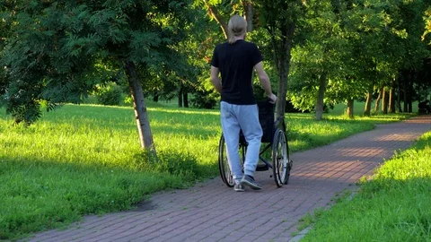 The man pushing a wheelchair. Stock Footage 77945269
