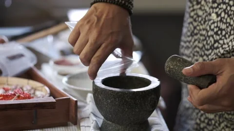 A man is put  Asian ingredients to a mortar  Stock Footage 146250159
