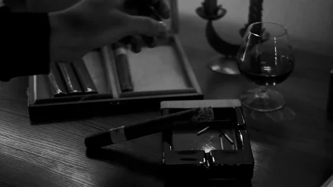 The man put the cigar on the ashtray and took a glass of whiskey. Stock Footage 83686076