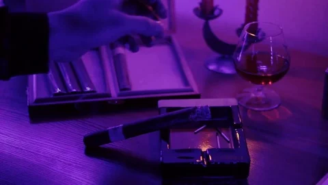 The man put the cigar on the ashtray and took a glass of whiskey. Stock Footage 83686162