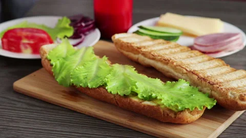 Man put ham pieces on salad lettuce leaves sandwich prepare Stock Footage 104289727