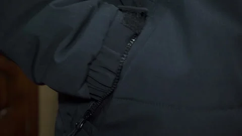 A man put his hand into the side pocket of a black jacket Stock Footage 328966472