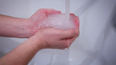 A man put his palms under the tap with clean and running water Stock Footage 315968390