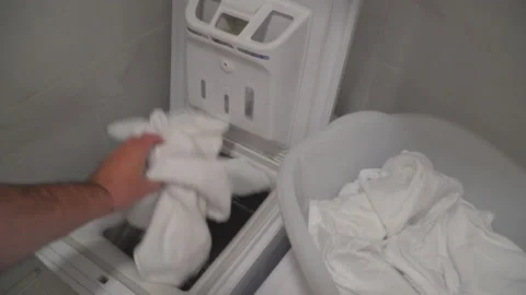 Man put laundry into washing machine Stock Footage 144962291