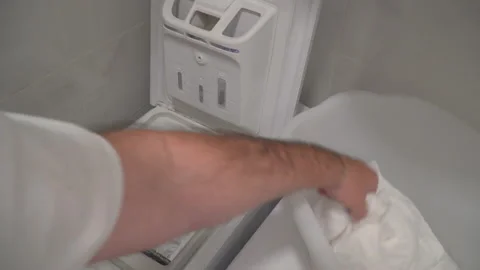 Man put laundry into washing machine Stock Footage 144965299