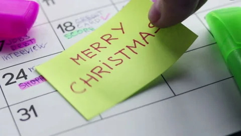 Man put paper note with merry christmas on calendar Stock Footage 116906734