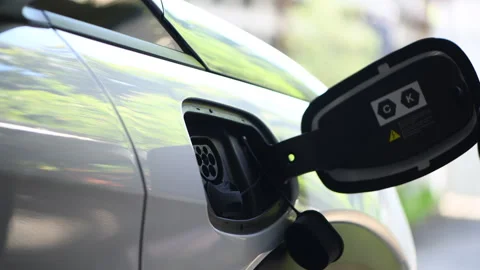 Man put plugs charging cable electric vehicle. Stock Footage 253500128