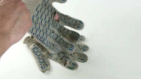 Man put on ragged dirty construction gloves on a white background. Stock Footage 143014265