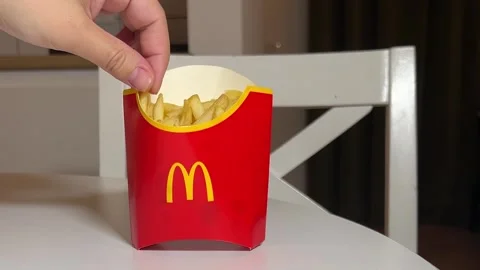 Man put in red paper bag with yellow McDonald's logo. Woman takes potato Stock Footage 311422289
