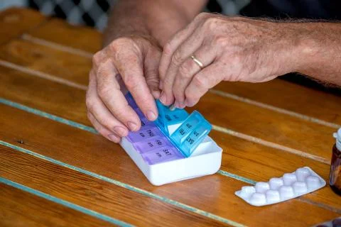 Man put tablets into the everyday container, medicine concept, targeted focus Stock Photos