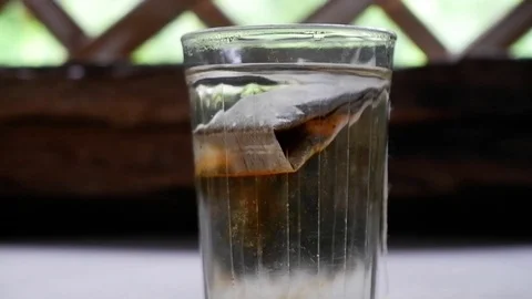 Man put a tea bag in a transparent faceted glass Video stock 122158296