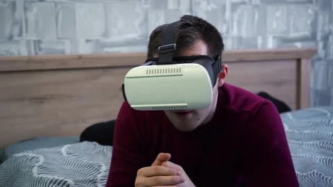 A man put on vr glasses and watches a movie Stock Footage 152636569