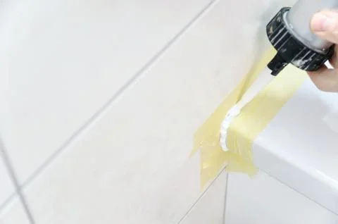 A man is puting the silicone sealant. Stock Photos