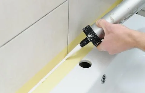 A man is puting the silicone sealant. Stock Photos