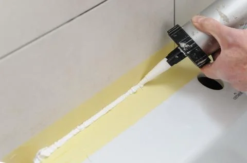 A man is puting the silicone sealant. Stock Photos