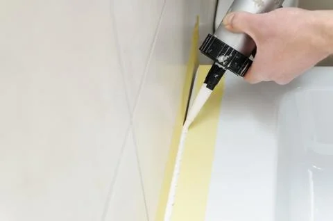 A man is puting the silicone sealant. Stock Photos