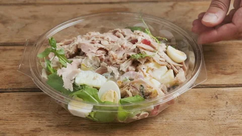 Man puts and open plastic package with healthy baked ham salad Stock Footage 218455551