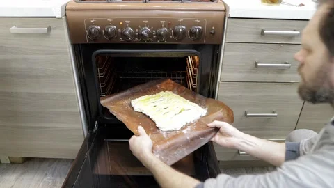 A man puts an apple pie in the oven, homemade cakes Vídeo Stock 205466176