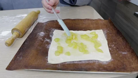 A man puts apples on the dough to make a homemade pie 動画素材 169700277