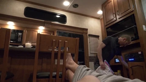 Man Puts Away Items Inside Fifth Wheel RV Camper Stock Footage