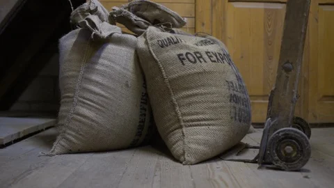 Man puts bag of cereal grains on wheelbarrow Stock Footage 127849068