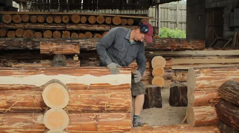 A man puts beam for future home. Construction works with a wooden structure Stock Footage 65414499