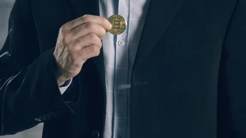 Man puts bitcoin in pocket of jacket Stock Footage 83383420