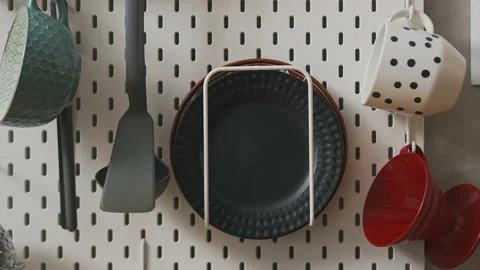 A man puts a black plate on a broom holder in the kitchen Stock Footage 172503245