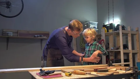 Man puts boy on the board in the workshop Stock Footage 126712925