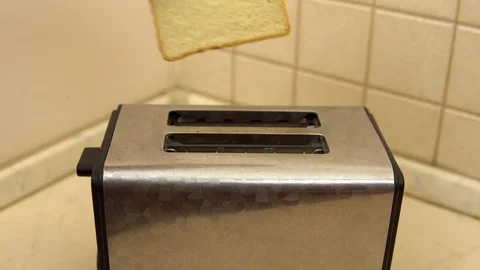 A man puts bread in a toaster. The bread is fried. Breakfast food is being Stock Footage 121474591