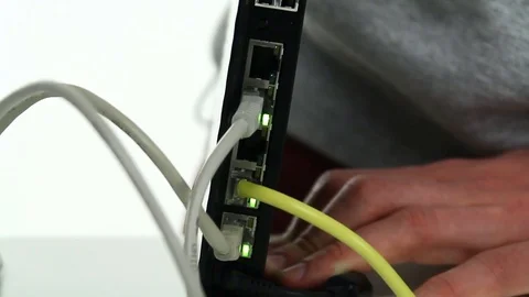 Man puts the cable into the router 库存影片 69896766