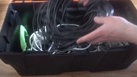 The man puts the cable in the tool box,and then closes it Video stock 75912470