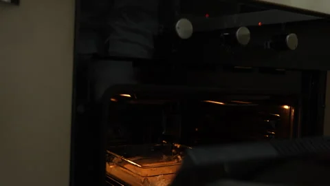 Man puts cake in oven Stock Footage 294884277