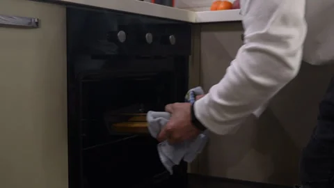 Man puts cake in oven Stock Footage 294884532