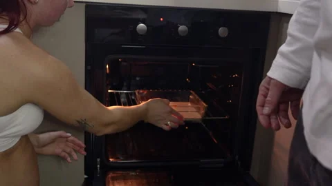 Man puts cake in oven Stock Footage 294884580