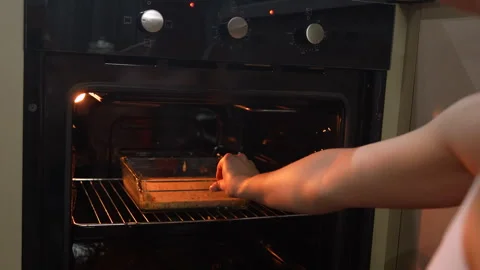 Man puts cake in oven Stock Footage 294884632