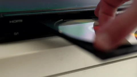 Man puts cd disc to a video player tray. Physical media concept.	 Stock Footage 301557025