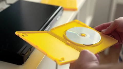 Man puts cd disc to a video player tray. Physical media concept.	 Stock Footage 301557118