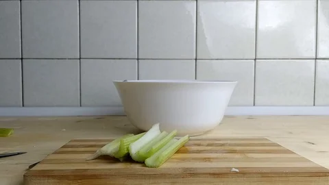 Man puts celery on a cutting board Video stock 129845463