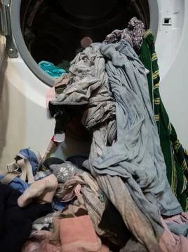Man puts clothes in the washing machine, close-up Stock Photos