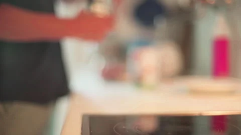 A man puts a coffee kettle on an electric stove Stock Footage 265074060