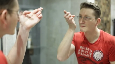 Man puts on contact lenses 库存影片 89917030