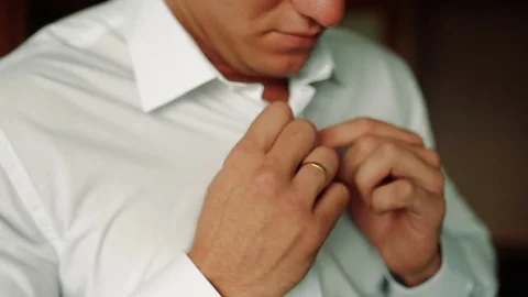 Man puts cufflinks on sleeve white shirts Stock Footage 84775135