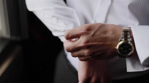 Man puts cufflinks on sleeves of white shirt. Close-up Stock Footage 45881442