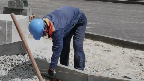 Man puts curbs on construction site 10.06.2020 Stock Footage 132493581