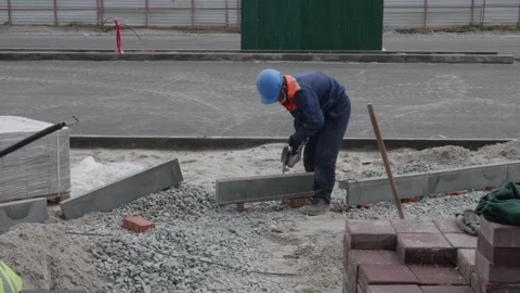 Man puts curbs on construction site 10.06.2020 Stock Footage 132493668